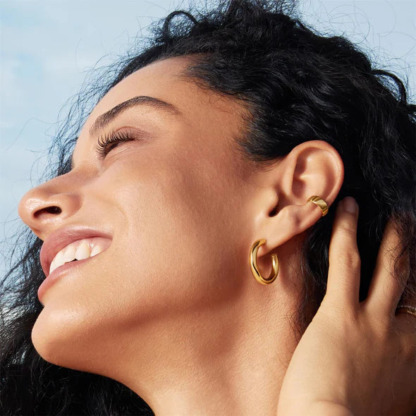 Gold Classic Tube Medium Huggie Hoop Earrings, view 2, styled