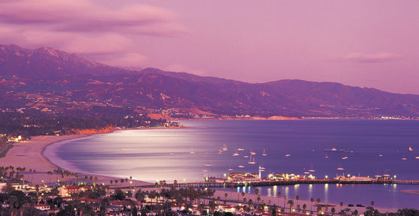 Santa Barbara harbor at dusk with boats and the mountains behind