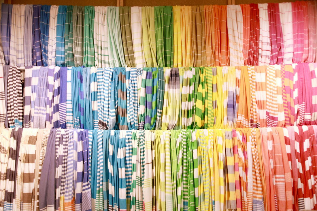 A rainbow wall of striped Turkish towels in every color, stacked shelf on shelf