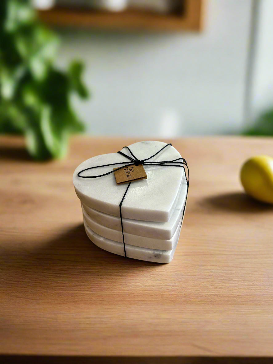 Stack of heart-shaped coasters tied with black string on a wooden surface with a blurred background
