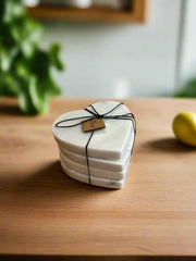 Stack of heart-shaped coasters tied with black string on a wooden surface with a blurred background