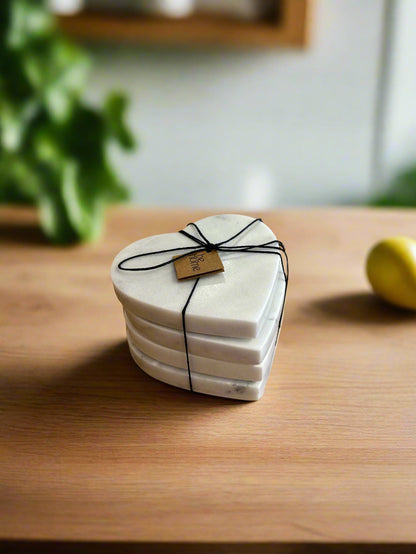 Stack of heart-shaped coasters tied with black string on a wooden surface with a blurred background