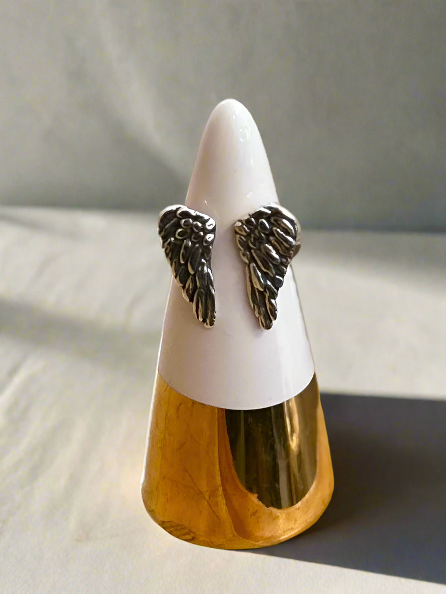 Decorative item with angel wings on a white and gold cone-shaped stand