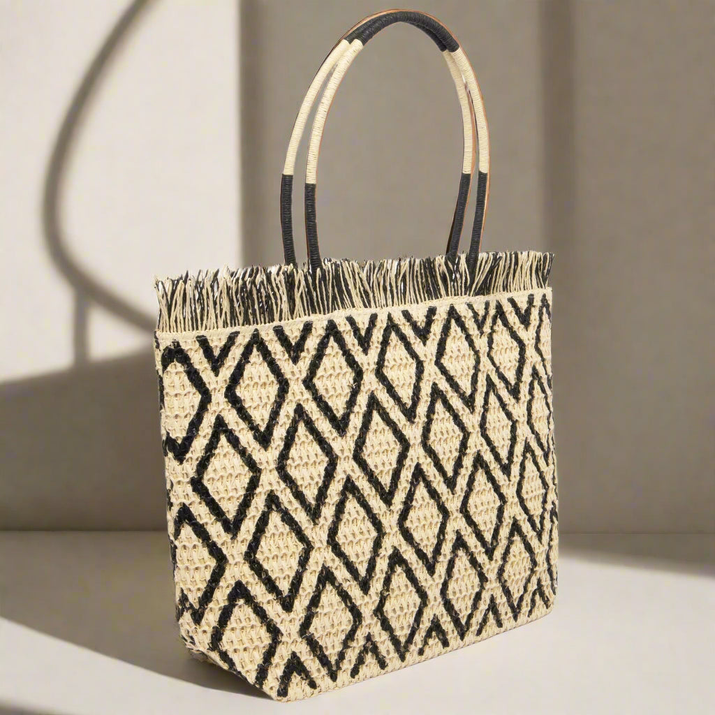 Woven tote bag with geometric pattern and black handles on a white background