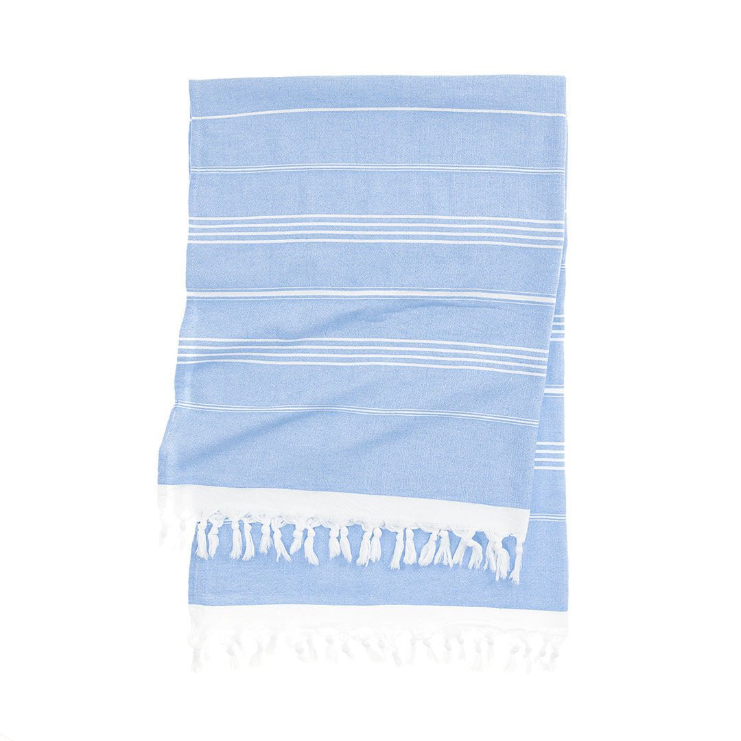 Essential Turkish towel with bold colored stripes on beach sand