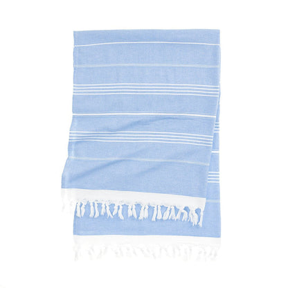 Essential Turkish towel with bold colored stripes on beach sand