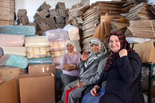 Artisans at the finishing workshop surrounded by towels