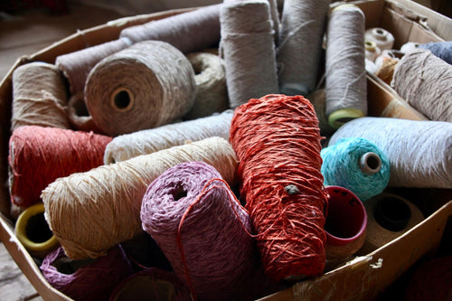 Basket of colorful cotton yarn cones