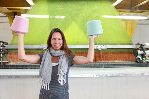 Holding bobbins of pastel cotton yarn at the loom