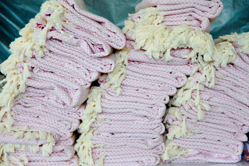 Stacks of pink towels with yellow fringe